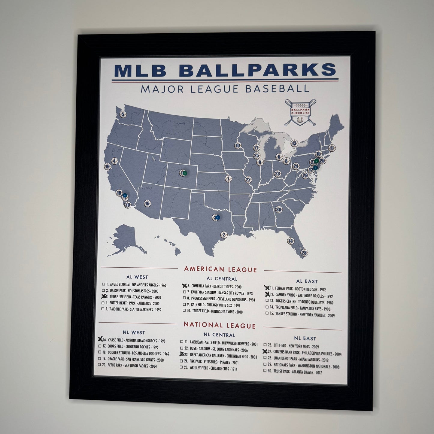 Framed poster of MLB ballparks map on a gray wall